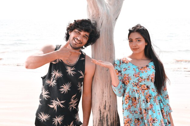 giovane coppia felice posa anteriore in spiaggia modello pakistano indiano