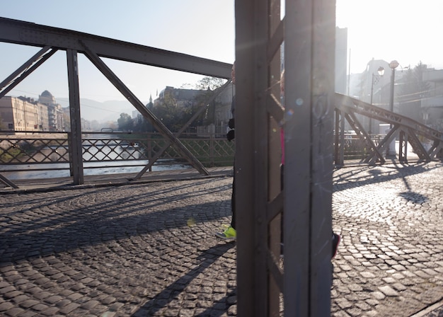 giovane coppia in buona salute che fa jogging in città al mattino presto con l'alba sullo sfondo