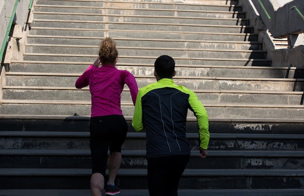 giovane coppia in buona salute che fa jogging sui gradini al mattino presto