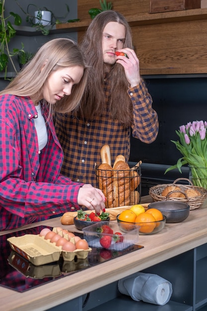 Giovane coppia in cucina Giovane donna che raccoglie fragole
