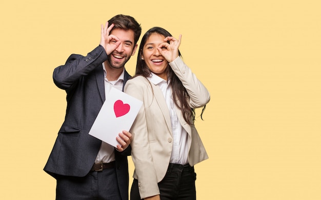 Giovane coppia in giorno di San Valentino fiducioso facendo ok gesto sull&#39;occhio