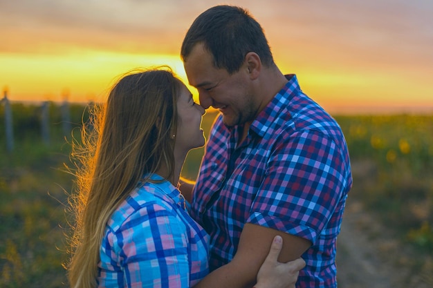 Giovane coppia in un campo di girasoli ragazza incinta in girasoli