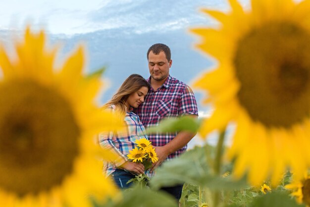 Giovane coppia in un campo di girasoli ragazza incinta in girasoli