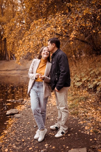 Giovane coppia innamorata all'aperto Splendido ritratto sensuale di una giovane coppia alla moda in posa in un parco in autunno vicino a un lago