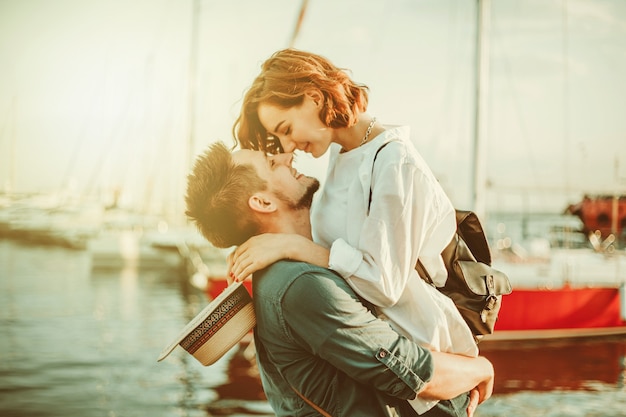 Giovane coppia innamorata in mare su uno sfondo di yacht club