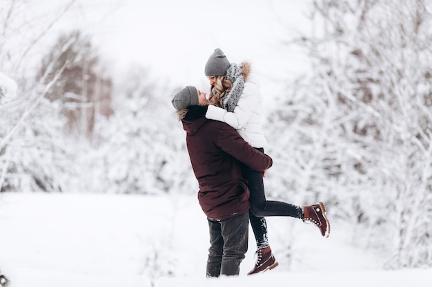 Giovane coppia innamorata inverno nevoso all'aperto