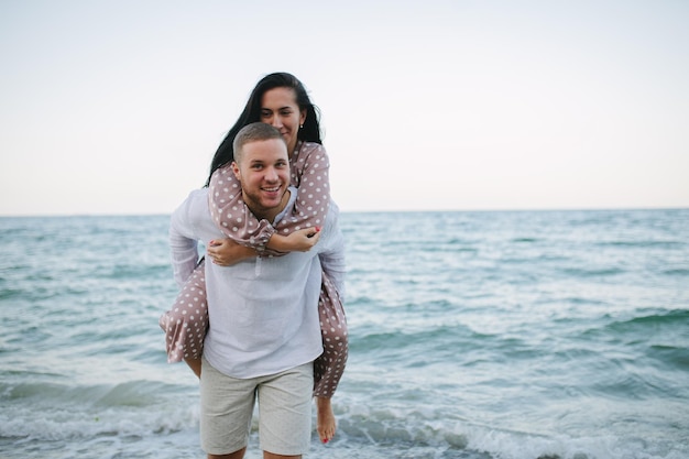 Giovane coppia innamorata Uomo e donna attraenti che si godono una serata romantica sulla spiaggia a guardare il tramonto