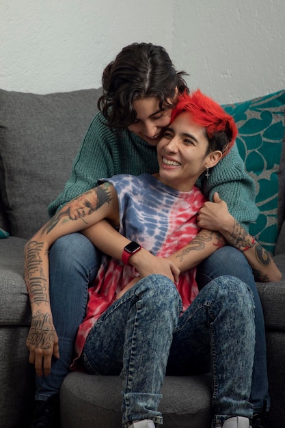Giovane coppia lesbica felice nel soggiorno della loro casa che ha un momento romantico insieme