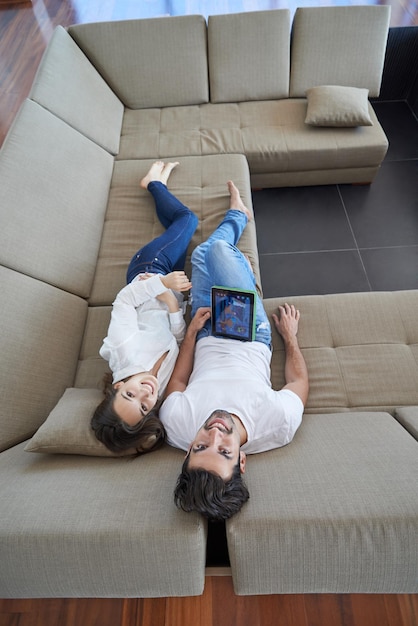 giovane coppia rilassata romantica a casa moderna utilizzando il computer tablet