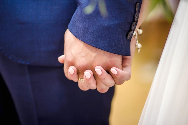 Giovane coppia sposata che si tiene per mano cerimonia del matrimonio