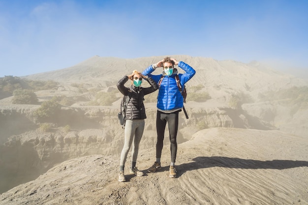 Giovane coppia uomo e donna visitano il vulcano bromo al parco nazionale di tengger semeru a java