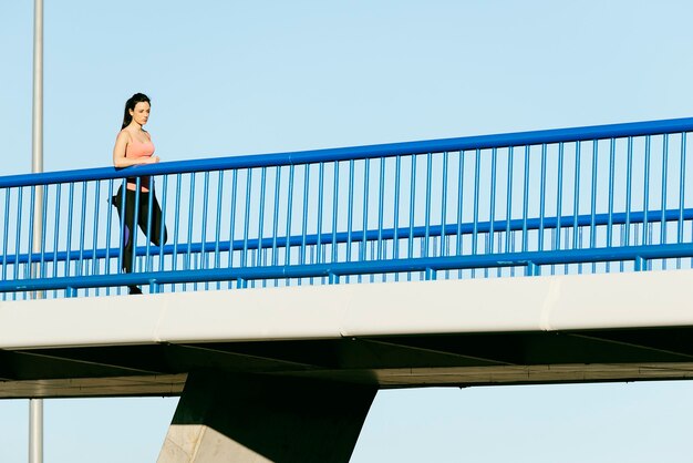 Giovane corridore della donna di forma fisica che allunga le gambe dopo l'esecuzione. Concetto di sport.