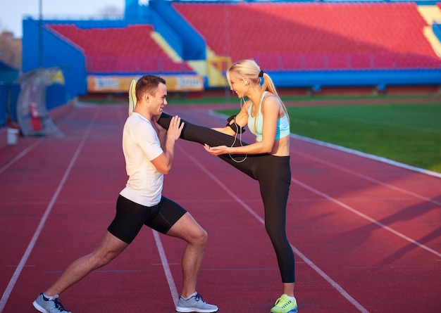 giovane corridore donna sportiva rilassante e stretching su pista atletica