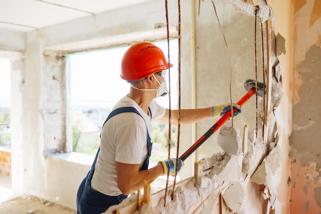 Giovane costruttore maschio in strumenti di tenuta per elmetti Concetto di riparazione e ristrutturazione dell'appartamento