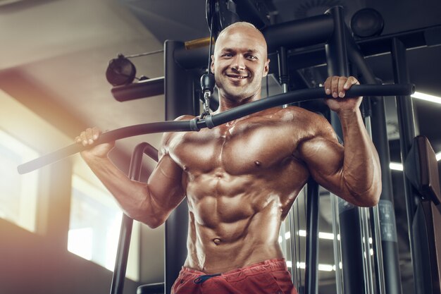 Giovane culturista bello in palestra