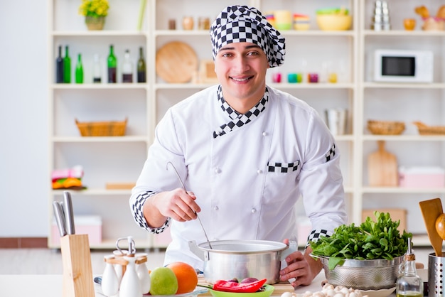 Giovane cuoco maschio che lavora in cucina