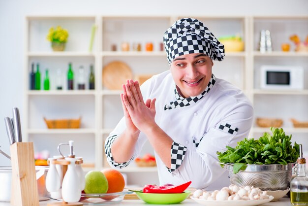 Giovane cuoco maschio che lavora in cucina