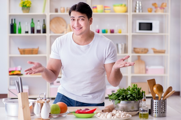 Giovane cuoco maschio che lavora in cucina