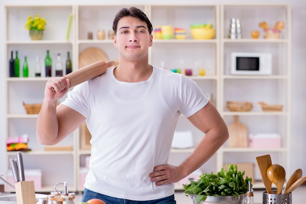 Giovane cuoco maschio che lavora in cucina