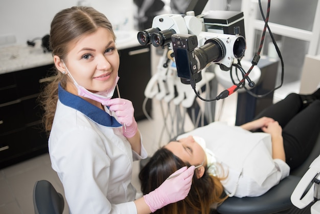 giovane dentista femmina amichevole con paziente in studio dentistico