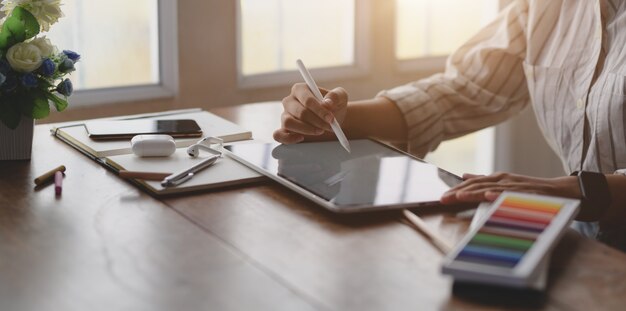 giovane designer femminile professionale lavorando su tablet schermo vuoto