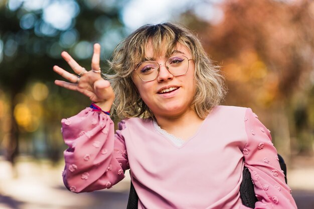 Giovane disabile con paralisi cerebrale in sedia a rotelle saluto e sorriso inclusione sociale