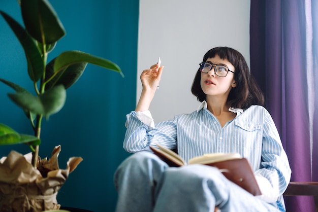 Giovane donna a casa che scrive e lavora con Notebook Freelancer lavora e prende appunti