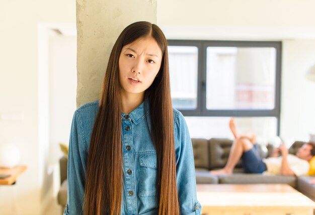 Giovane donna abbastanza asiatica che si sente perplessa e confusa