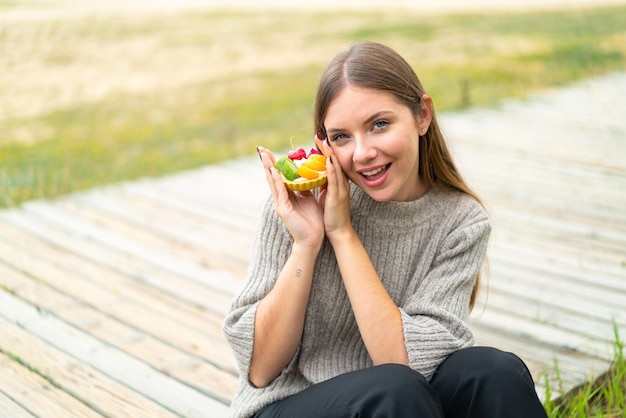 Giovane donna abbastanza bionda che tiene un tortino