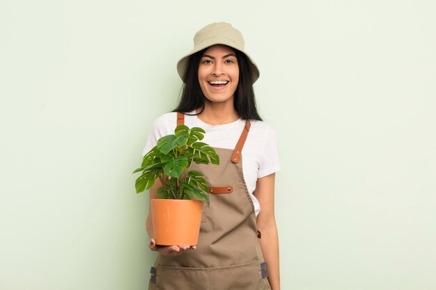 giovane donna abbastanza ispanica che sembra felice e piacevolmente sorpresa concetto di coltivatore o giardiniere