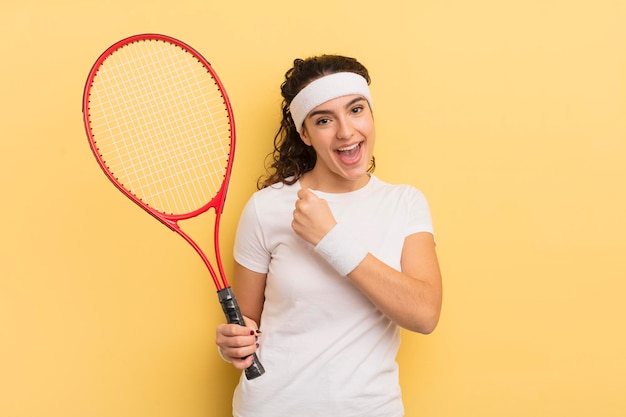 Giovane donna abbastanza ispanica che si sente felice e affronta una sfida o festeggia. concetto di tennis
