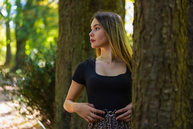 Giovane donna accanto a un albero in natura in un parco naturale