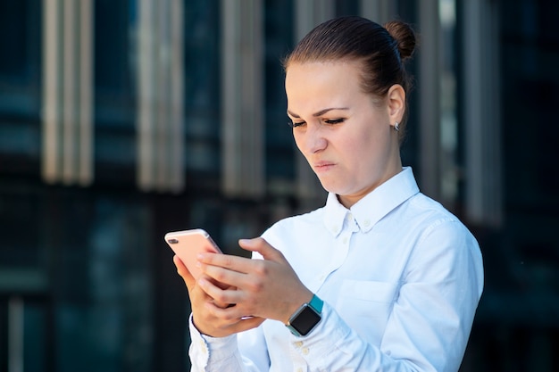 Giovane donna accigliata disgustata aggrottante le sopracciglia arrabbiata che pratica il surfing smartphone nello antipatia