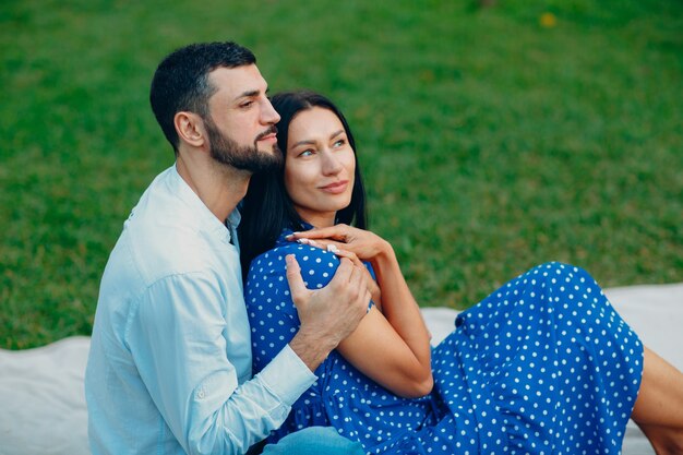 Giovane donna adulta e uomo che abbraccia coppia picnic al prato di erba verde nel parco.