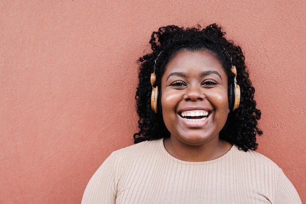 Giovane donna africana che ascolta musica con le cuffie - Focus sul viso