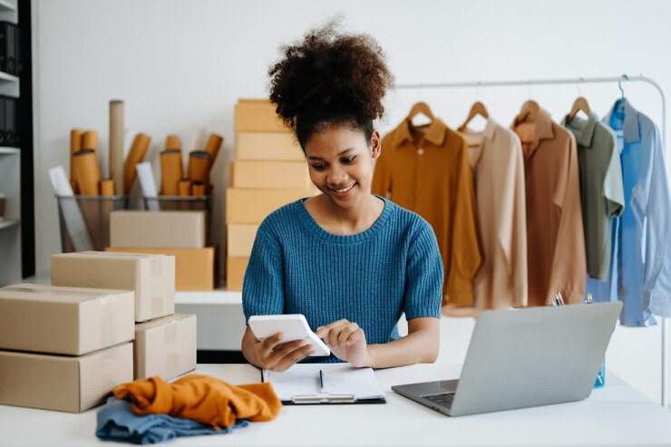 Foto giovane donna africana che gestisce un negozio online startup piccola impresa pmi che utilizza smartphone o tablet che riceve e controlla l'ordine di acquisto online in ufficio