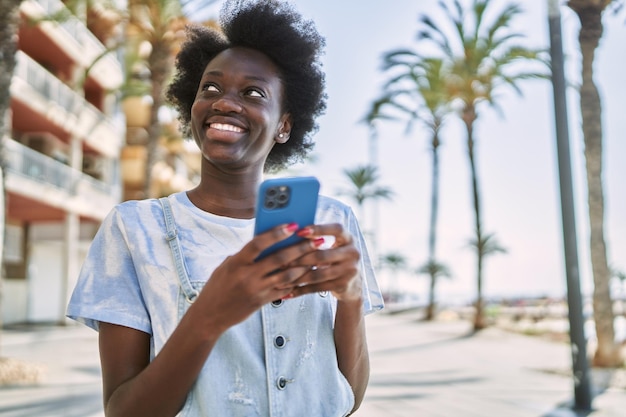 Giovane donna africana che usa lo smartphone in strada