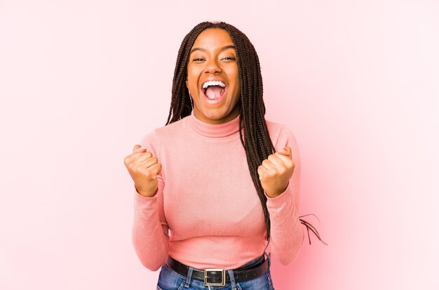 Giovane donna afro-americana che incoraggia spensierata ed emozionata. Concetto di vittoria.