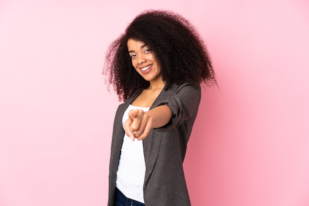 Giovane donna afro-americana che punta davanti con felice espressione