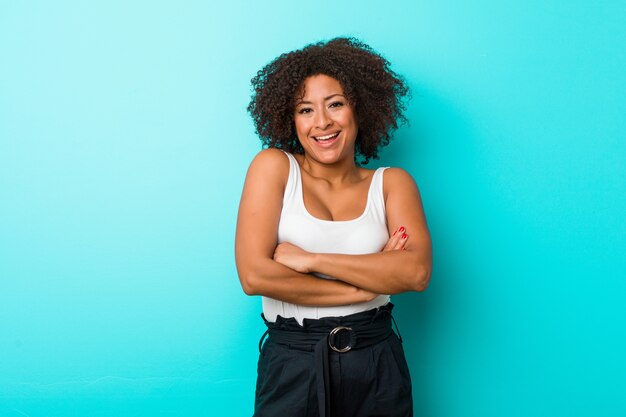 Giovane donna afro-americana che si sente sicura, incrociando le braccia con determinazione.