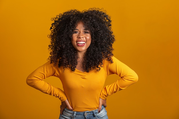 Giovane donna afro-americana con i capelli ricci e sorridente. Ragazza afro sveglia con sorridere dei capelli ricci