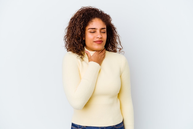 Giovane donna afro-americana isolata su sfondo bianco soffre di dolore alla gola a causa di un virus o infezione.