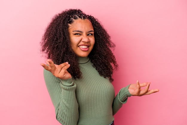 Giovane donna afro-americana isolata su sfondo rosa gioiosa ridendo molto. Concetto di felicità.