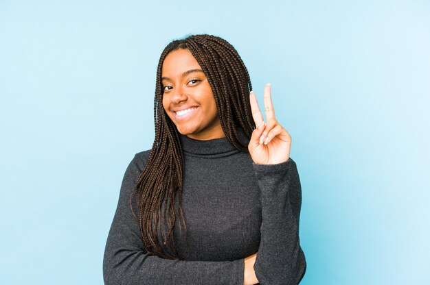 Giovane donna afro-americana isolata sul blu che mostra il numero due con le dita.