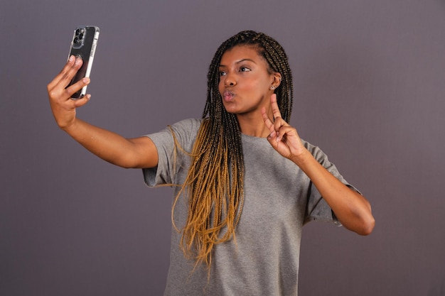 Giovane donna afro brasiliana che prende lo smartphone dei social network della foto del selfie dell'autoritratto