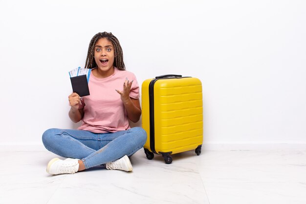 Giovane donna afro che sembra disperata e frustrata, stressata, infelice e infastidita, gridando e urlando. concetto di vacanze