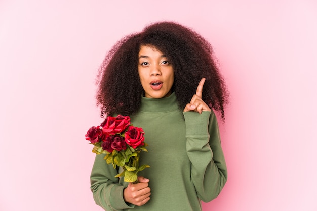 Giovane donna afro che tiene le rose i