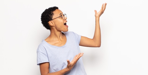 Giovane donna afro nera che esegue l'opera o canta a un concerto o uno spettacolo, sentendosi romantica, artistica e appassionata