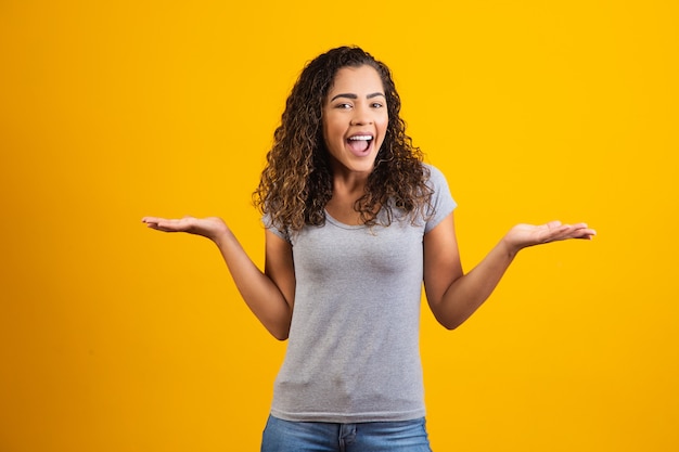 Giovane donna afro sorridente su sfondo giallo con spazio libero per il testo. giovane studente