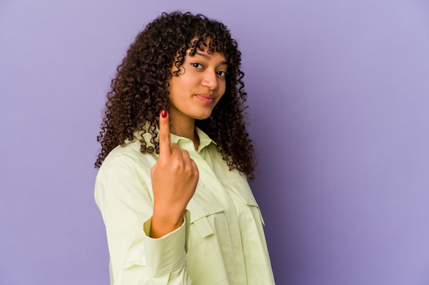 Giovane donna afroamericana afro isolata che indica con il dito contro di voi come se invitando ad avvicinarsi.